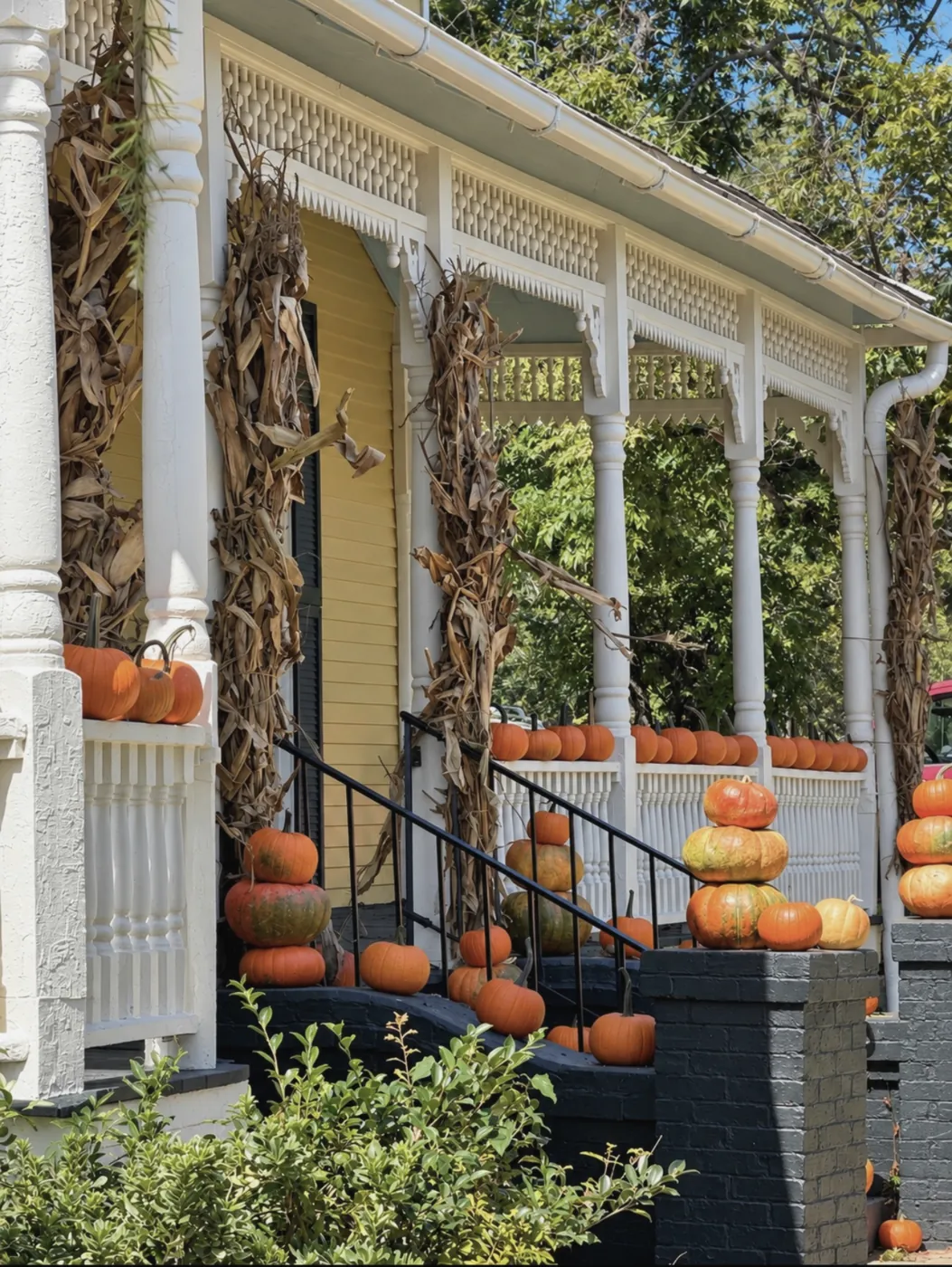 VanCleave Hall's porch steps lined with stacked pumpkins and corn stalks wrapped around the white columns