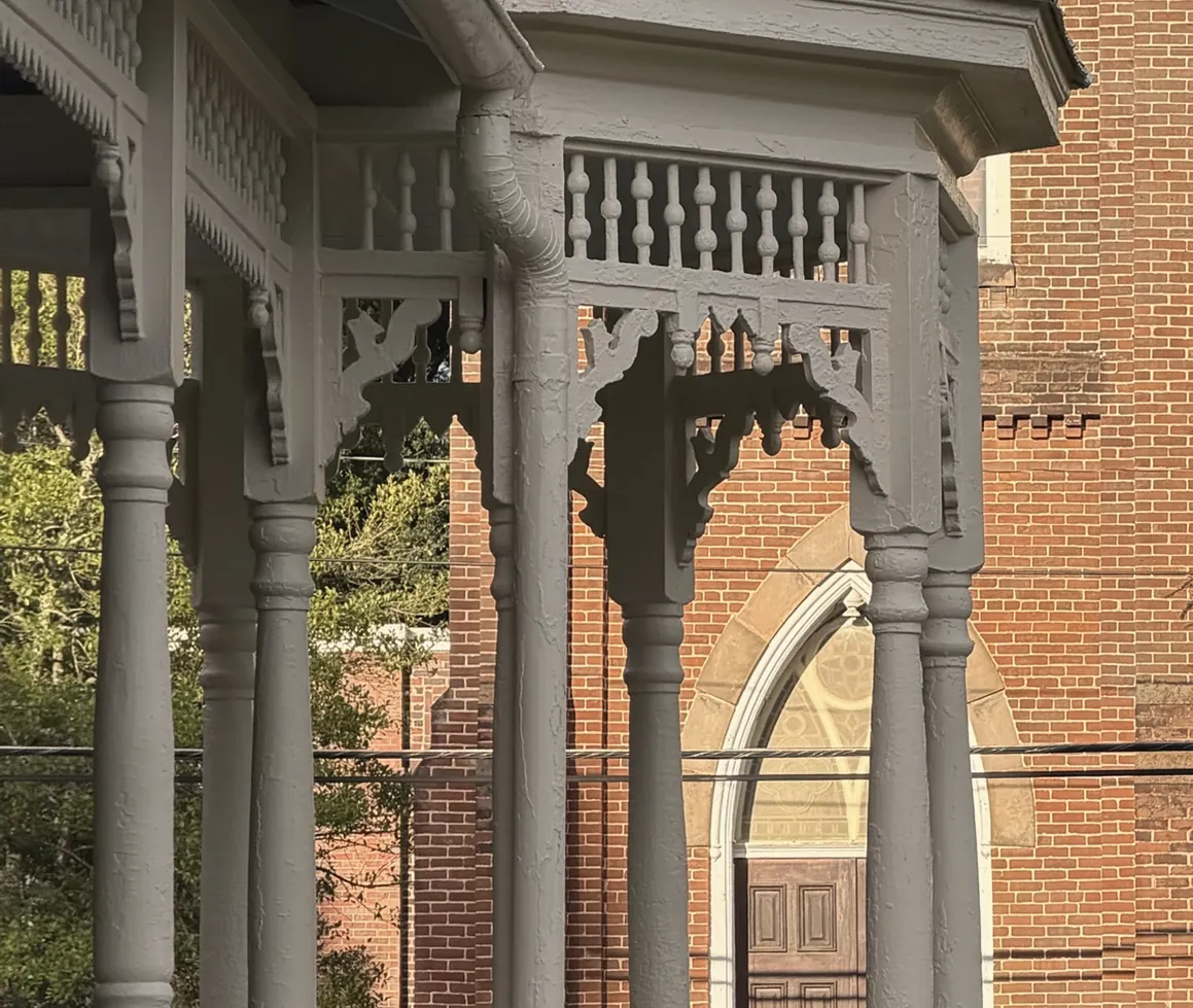 Spindle frieze, gingerbread brackets and turned columns of the turret