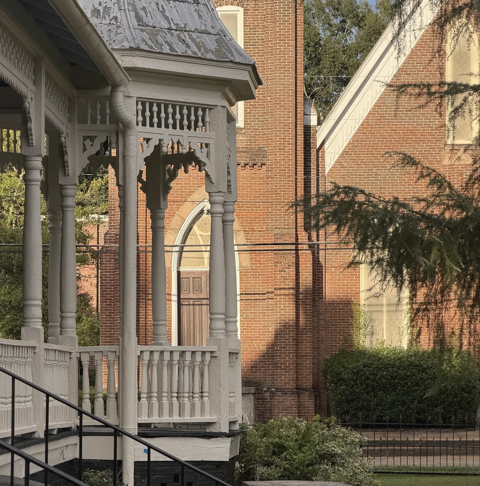The turret's spindle frieze and turned columns in golden evening light